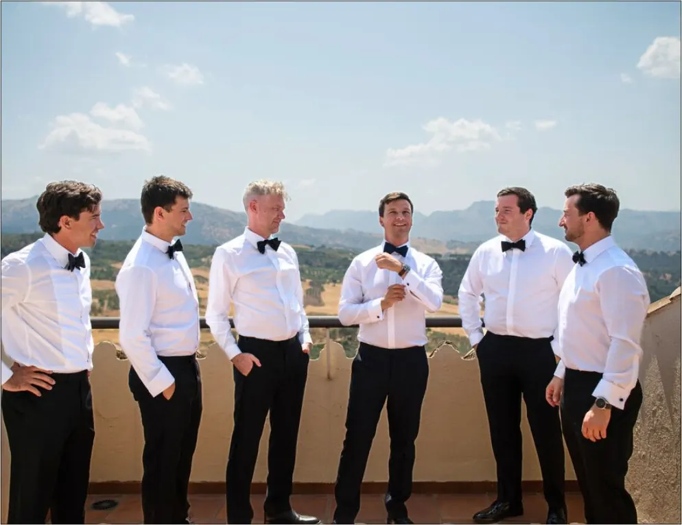 Novio y amigos con vistas a la montaña antes de la boda