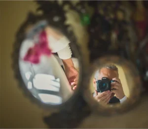 Fotógrafo de bodas reflejado en un espejo mientras fotografía a la novia