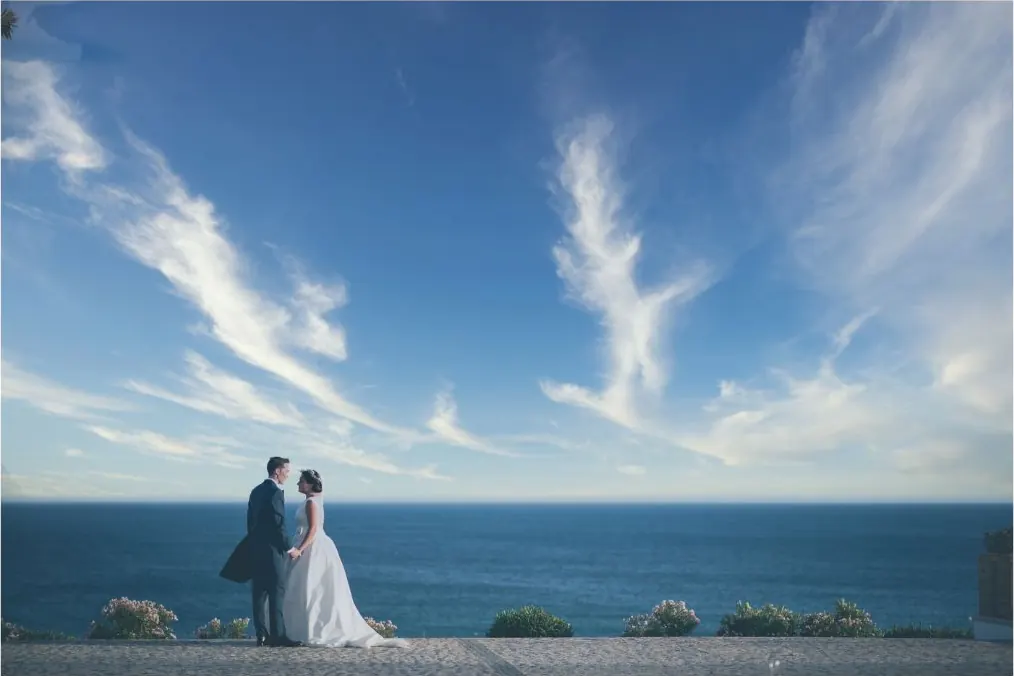 Couple embracing on a clifftop by the sea during their elopement