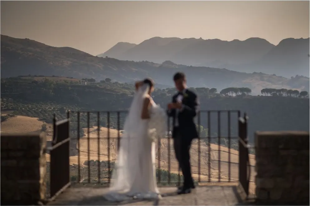 Bride and groom on a balcony with mountain views in Andalusia