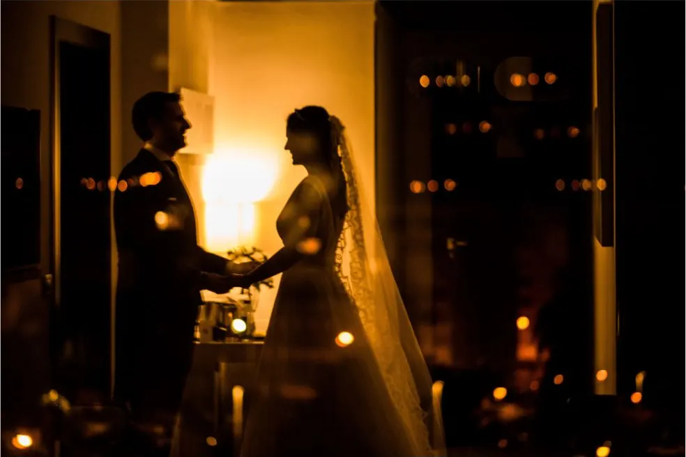 Novios en un interior iluminado con velas el día de su boda