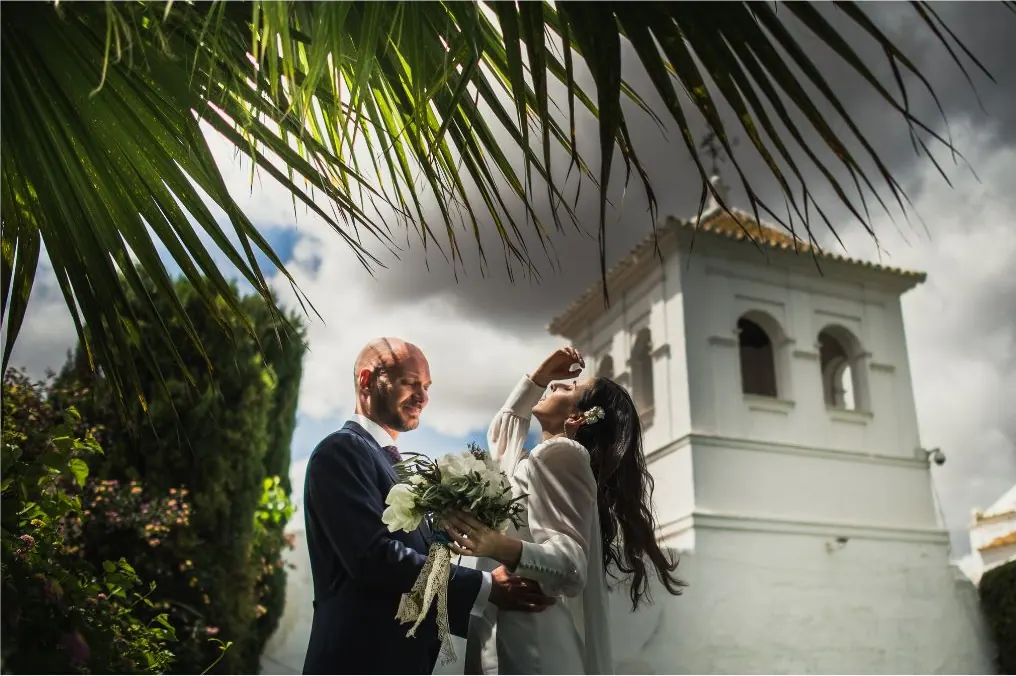 Wedding ceremony outdoors next to a white Andalusian bell tower