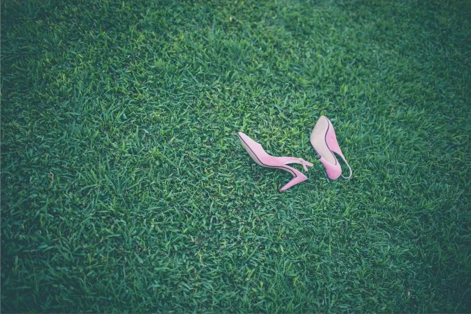 Zapatos de novia sobre el césped del jardín de la boda