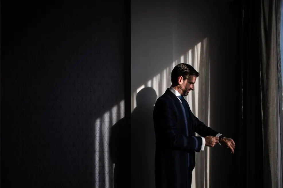 Novio preparándose junto a la ventana antes de la boda