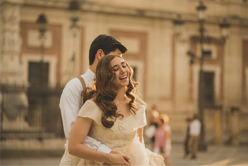 Couple laughing and embracing in a historic street in Seville