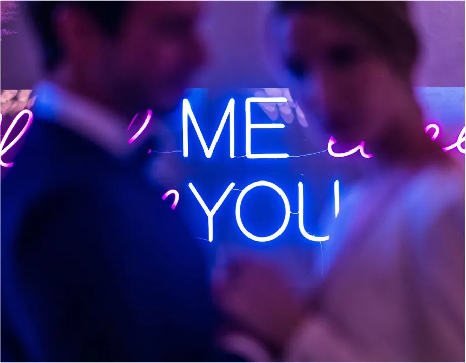 Couple in front of a neon sign during a celebration