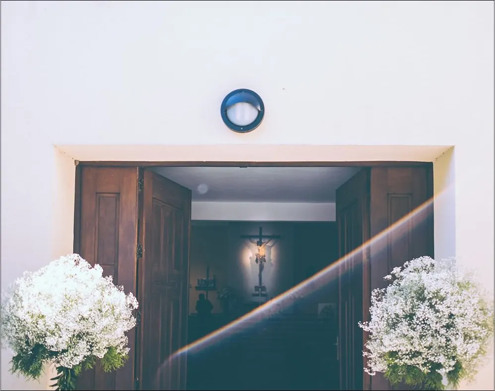 Puerta de una casa palacio decorada con flores blancas para una boda