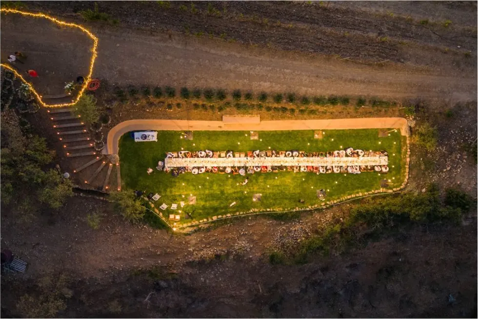 Vista aérea de una larga mesa de banquete de boda al atardecer